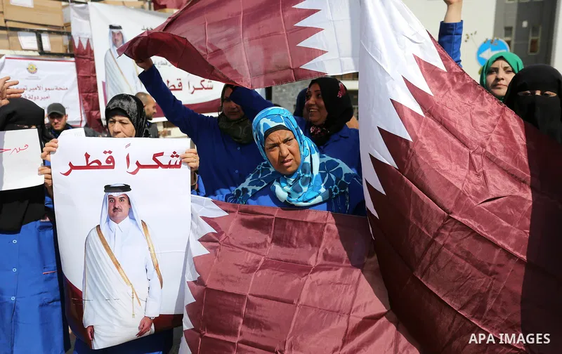 Palestinian cleaners in al-Shifa hospital hold Qatari flags and placards to demand thier salaries during a press conference of Qatar's Ambassador to the Palestinian Authority, Mohammed Al Emadi in Gaza city on February 1...