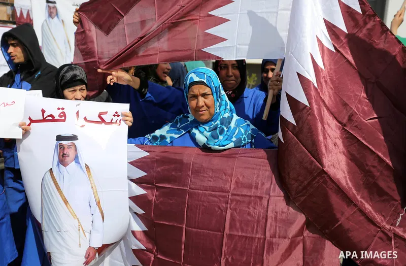 Palestinian cleaners in al-Shifa hospital hold Qatari flags and placards to demand thier salaries during a press conference of Qatar's Ambassador to the Palestinian Authority, Mohammed Al Emadi in Gaza city on February 1...