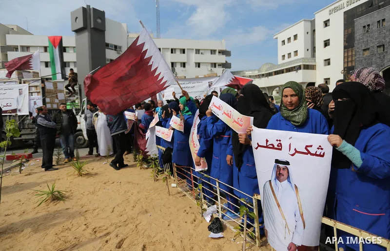 Palestinian cleaners in al-Shifa hospital hold Qatari flags and placards to demand thier salaries during a press conference of Qatar's Ambassador to the Palestinian Authority, Mohammed Al Emadi in Gaza city on February 1...
