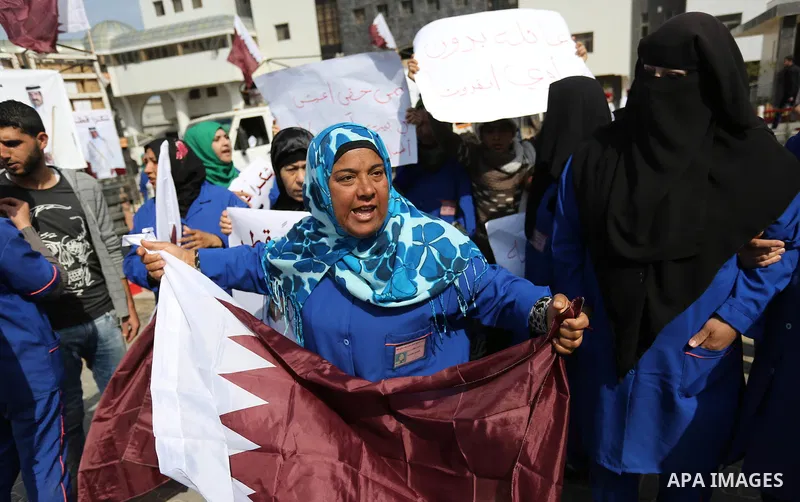 Palestinian cleaners in al-Shifa hospital hold Qatari flags and placards to demand thier salaries during a press conference of Qatar's Ambassador to the Palestinian Authority, Mohammed Al Emadi in Gaza city on February 1...