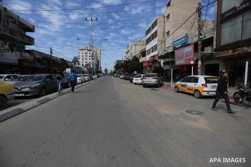 Palestinians walk at street in Gaza City on February 20, 2018 during a traffic jam caused by a general strike to protest the humanitarian situation in Gaza. Photo by Ashraf Amra