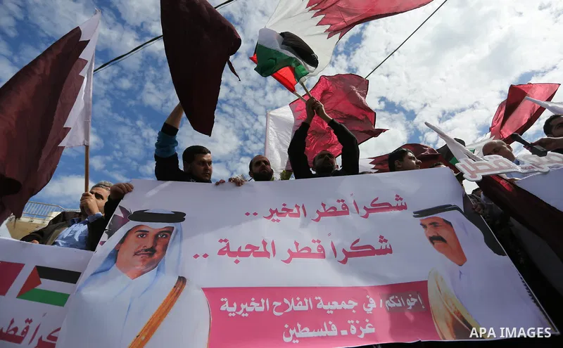 Palestinians hold Qatari flags and banners in a rally to say "Thank" to Qatar to provide a nine million dollar humanitarian relief grant to residents of the Gaza Strip, in Gaza city on February 20, 2018. Photo by Ashraf...