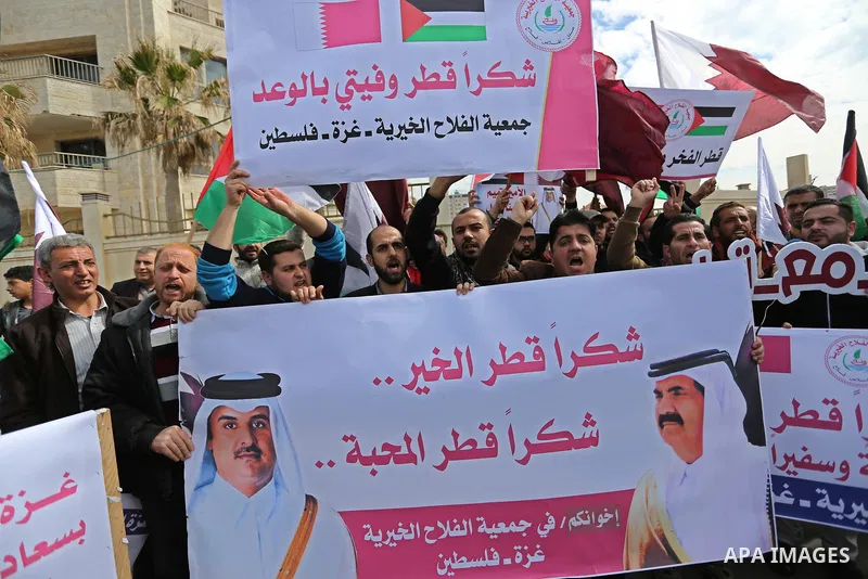 Palestinians hold Qatari flags and banners in a rally to say "Thank" to Qatar to provide a nine million dollar humanitarian relief grant to residents of the Gaza Strip, in Gaza city on February 20, 2018. Photo by Ashraf...