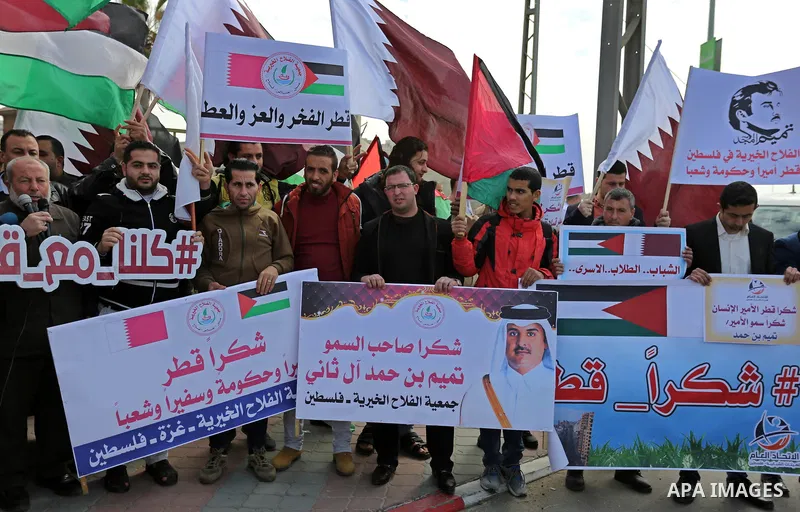 Palestinians hold Qatari flags and banners in a rally to say "Thank" to Qatar to provide a nine million dollar humanitarian relief grant to residents of the Gaza Strip, in Gaza city on February 20, 2018. Photo by Ashraf...