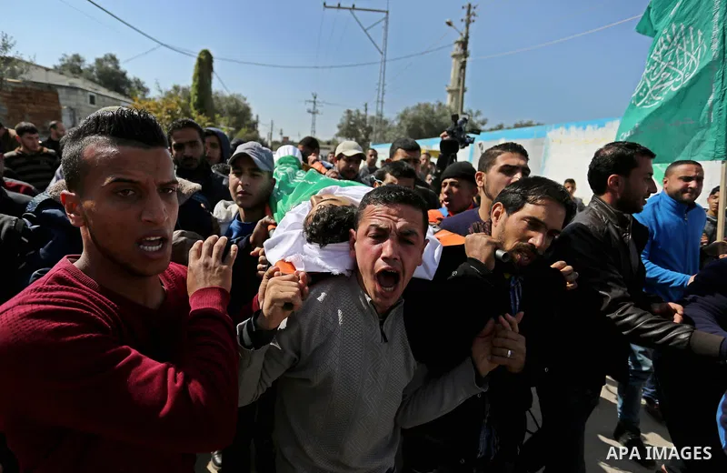 Mourners carry the body of Palestinian Ahmed Ebu Helou, 19, who died of his injuries after Israeli security forces shot him during clashes against US decision to recognize Jerusalem as Israel's capital, during his funera...
