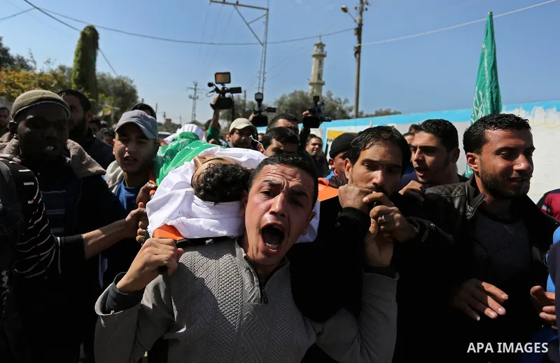 Mourners carry the body of Palestinian Ahmed Ebu Helou, 19, who died of his injuries after Israeli security forces shot him during clashes against US decision to recognize Jerusalem as Israel's capital, during his funera...