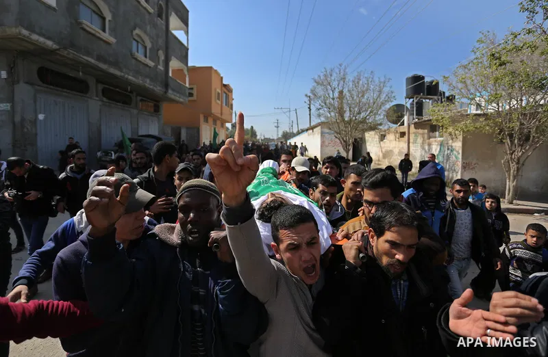 Mourners carry the body of Palestinian Ahmed Ebu Helou, 19, who died of his injuries after Israeli security forces shot him during clashes against US decision to recognize Jerusalem as Israel's capital, during his funera...
