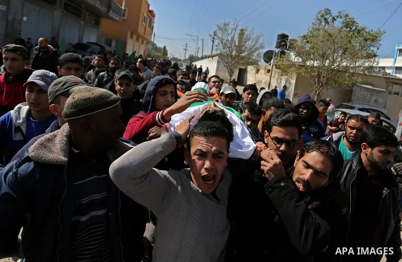 Mourners carry the body of Palestinian Ahmed Ebu Helou, 19, who died of his injuries after Israeli security forces shot him during clashes against US decision to recognize Jerusalem as Israel's capital, during his funera...