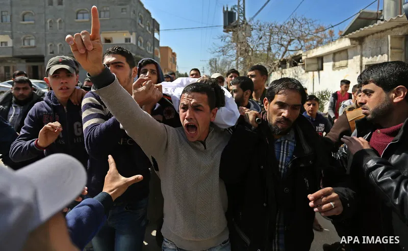 Mourners carry the body of Palestinian Ahmed Ebu Helou, 19, who died of his injuries after Israeli security forces shot him during clashes against US decision to recognize Jerusalem as Israel's capital, during his funera...