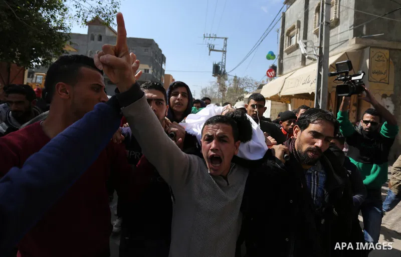 Mourners carry the body of Palestinian Ahmed Ebu Helou, 19, who died of his injuries after Israeli security forces shot him during clashes against US decision to recognize Jerusalem as Israel's capital, during his funera...