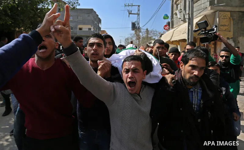 Mourners carry the body of Palestinian Ahmed Ebu Helou, 19, who died of his injuries after Israeli security forces shot him during clashes against US decision to recognize Jerusalem as Israel's capital, during his funera...