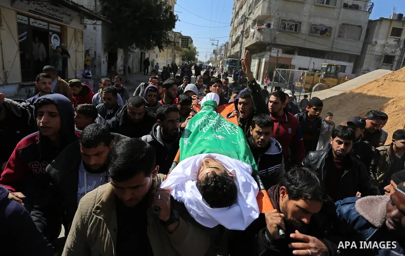 Mourners carry the body of Palestinian Ahmed Ebu Helou, 19, who died of his injuries after Israeli security forces shot him during clashes against US decision to recognize Jerusalem as Israel's capital, during his funera...