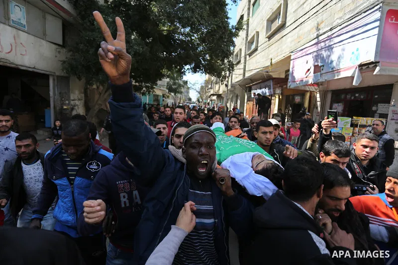 Mourners carry the body of Palestinian Ahmed Ebu Helou, 19, who died of his injuries after Israeli security forces shot him during clashes against US decision to recognize Jerusalem as Israel's capital, during his funera...
