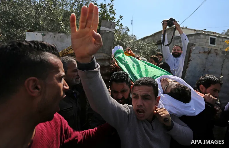 Mourners carry the body of Palestinian Ahmed Ebu Helou, 19, who died of his injuries after Israeli security forces shot him during clashes against US decision to recognize Jerusalem as Israel's capital, during his funera...