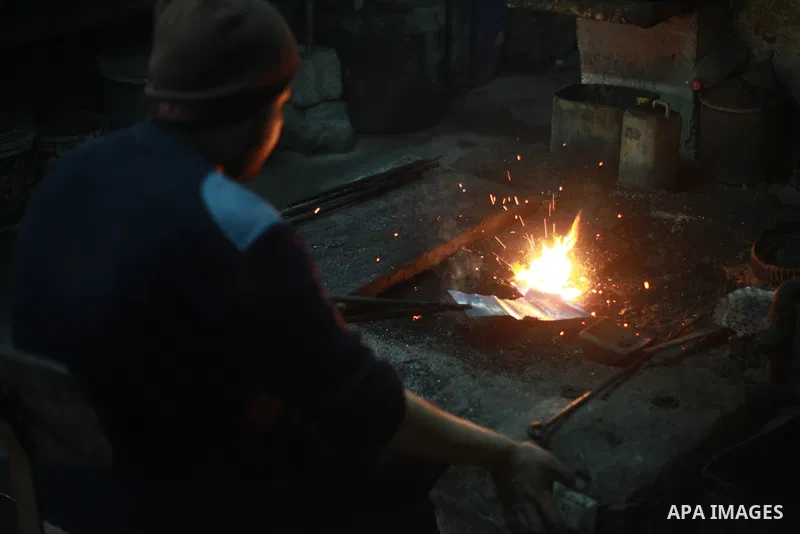 A Palestinian copper Ahmed Abdo, works at his father workshopt in Gaza city, on February 21, 2018. Abdo inherited copper profession from his father for nearly 40 years. Make replicas Crescent attached to mosques. He is t...