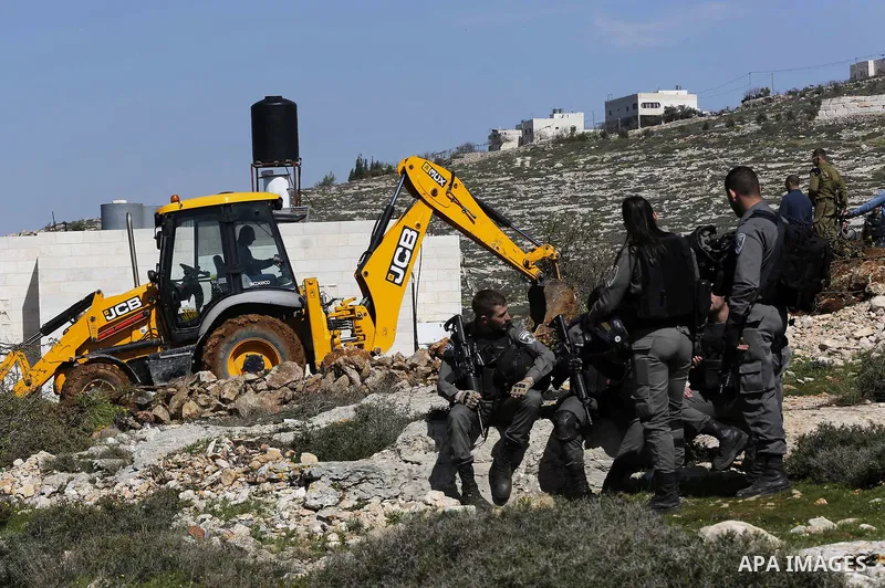 Israeli security forces stand guard as an Israeli machinery removes trees near a Jewish settlement in Hebron, in the occupied West Bank February 21, 2018. Photo by Wisam Hashlamoun