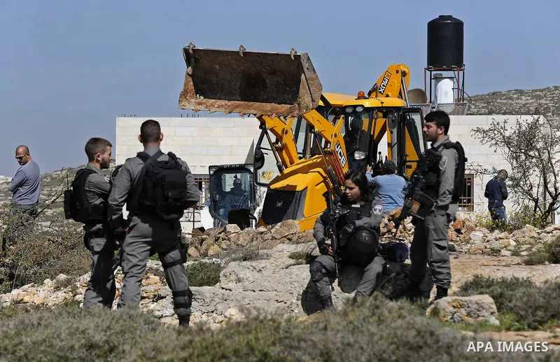 Israeli security forces stand guard as an Israeli machinery removes trees near a Jewish settlement in Hebron, in the occupied West Bank February 21, 2018. Photo by Wisam Hashlamoun