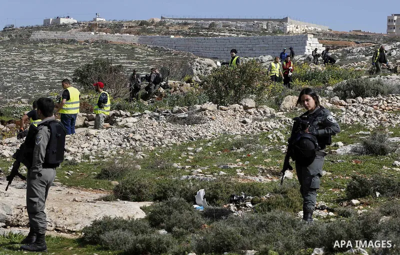 Israeli security forces stand guard as an Israeli machinery removes trees near a Jewish settlement in Hebron, in the occupied West Bank February 21, 2018. Photo by Wisam Hashlamoun
