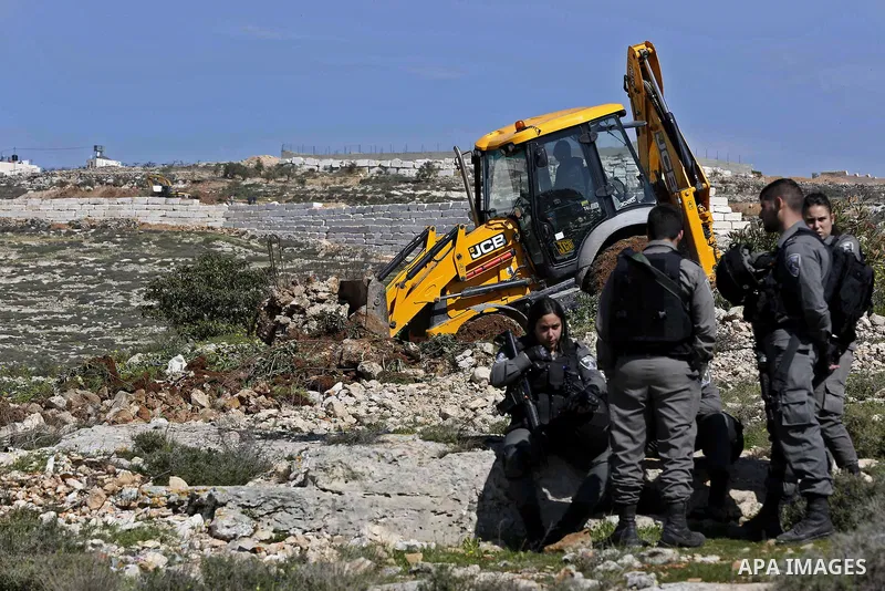 Israeli security forces stand guard as an Israeli machinery removes trees near a Jewish settlement in Hebron, in the occupied West Bank February 21, 2018. Photo by Wisam Hashlamoun