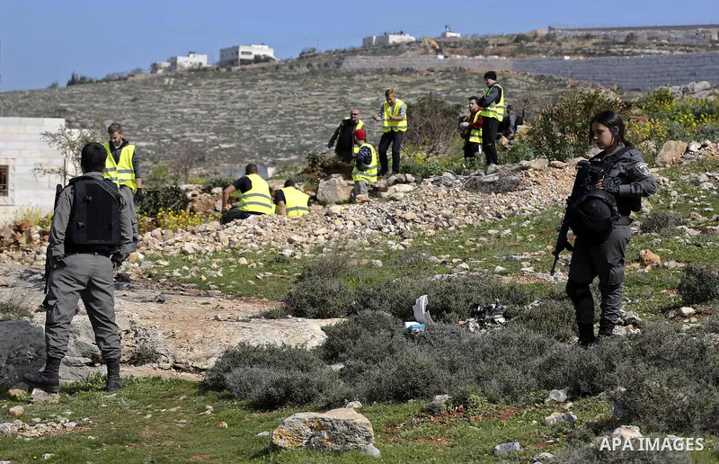 Israeli security forces stand guard as an Israeli machinery removes trees near a Jewish settlement in Hebron, in the occupied West Bank February 21, 2018. Photo by Wisam Hashlamoun