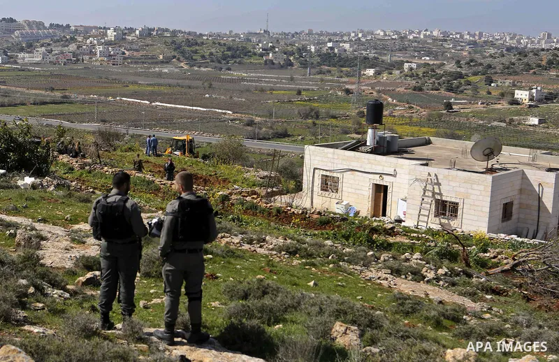 Israeli security forces stand guard as an Israeli machinery removes trees near a Jewish settlement in Hebron, in the occupied West Bank February 21, 2018. Photo by Wisam Hashlamoun