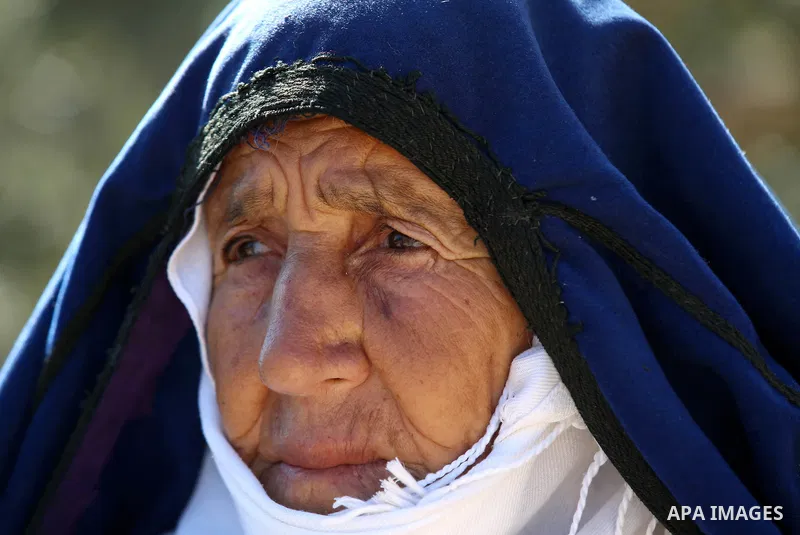 An elderly Palestinian woman Sobha Kassab 77, wears a traditional cloak or "Abaya" outside her house in the West Bank village of Qaryut, near Nablus on February 21, 2018. Decades ago, the cloack or "Abaya" was common for...