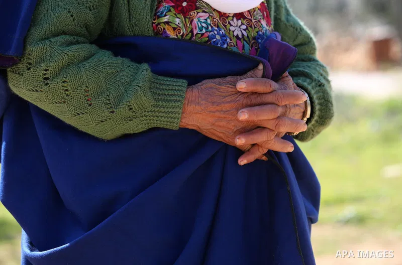 An elderly Palestinian woman Sobha Kassab 77, wears a traditional cloak or "Abaya" outside her house in the West Bank village of Qaryut, near Nablus on February 21, 2018. Decades ago, the cloack or "Abaya" was common for...
