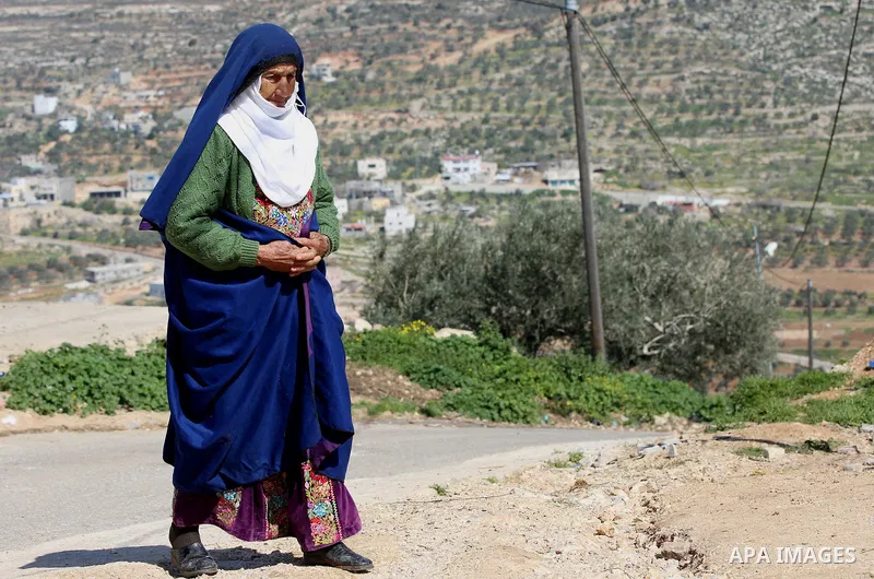 An elderly Palestinian woman Sobha Kassab 77, wears a traditional cloak or "Abaya" outside her house in the West Bank village of Qaryut, near Nablus on February 21, 2018. Decades ago, the cloack or "Abaya" was common for...