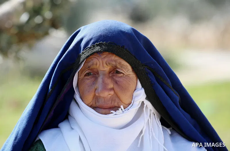 An elderly Palestinian woman Sobha Kassab 77, wears a traditional cloak or "Abaya" outside her house in the West Bank village of Qaryut, near Nablus on February 21, 2018. Decades ago, the cloack or "Abaya" was common for...