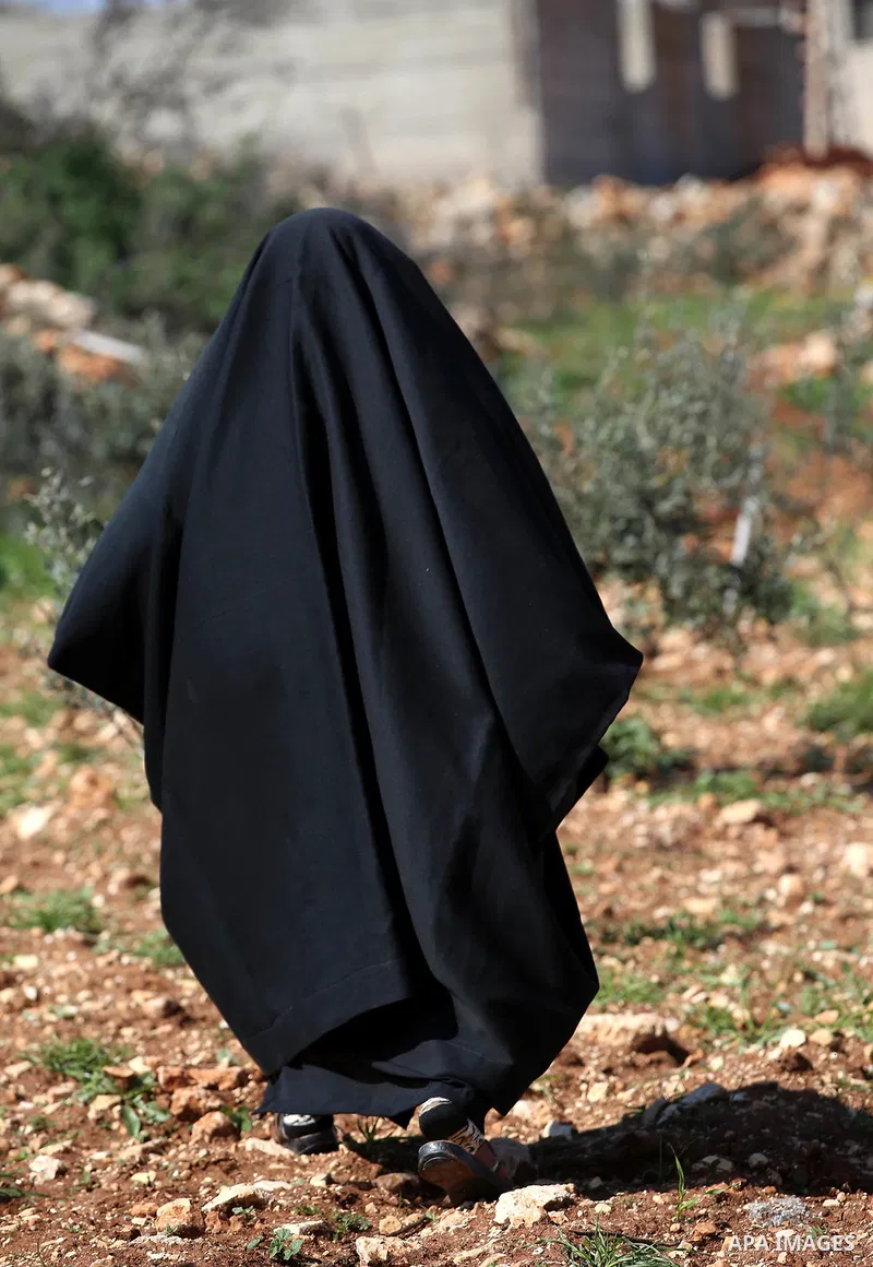 An elderly Palestinian woman Nada Auda 62, wears a traditional cloak or "Abaya" outside her house in the West Bank village of Qusra, near Nablus on February 21, 2018. Decades ago, the cloack or "Abaya" was common for vil...