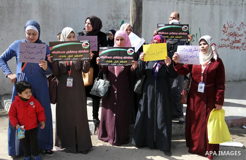 Palestinian graduates hold placards during a protest to demand their rights, outside the Ministry of Labor headquarters in Gaza city on February 25, 2018. Photo by Mahmoud Ajour