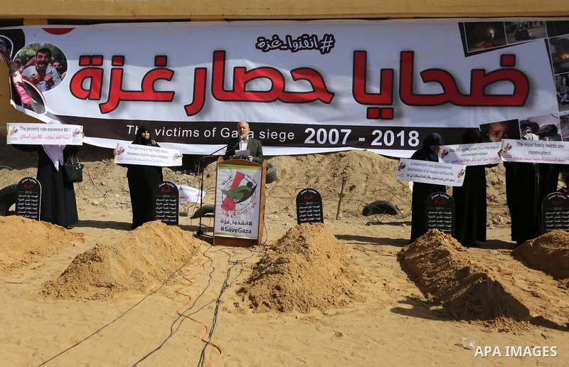 Palestinian women hold banners during a protest against the siege on the Gaza Strip in Gaza City on February 25, 2018. Israel has maintained a siege on Gaza for a decade which it says is necessary to limit Hamas, the Isl...