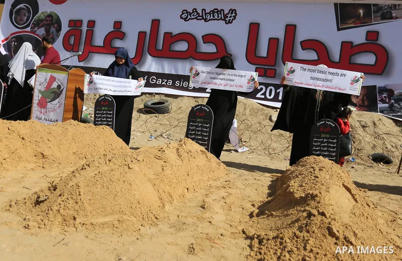 Palestinian women hold banners during a protest against the siege on the Gaza Strip in Gaza City on February 25, 2018. Israel has maintained a siege on Gaza for a decade which it says is necessary to limit Hamas, the Isl...
