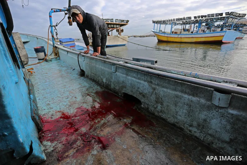 A Palestinian man inspects a boat at the port in Gaza City on February 26, 2018 in which a fisherman was killed when Israeli forces opened fire on it the previous day. A spokeswoman for the Israeli army said the boat "de...