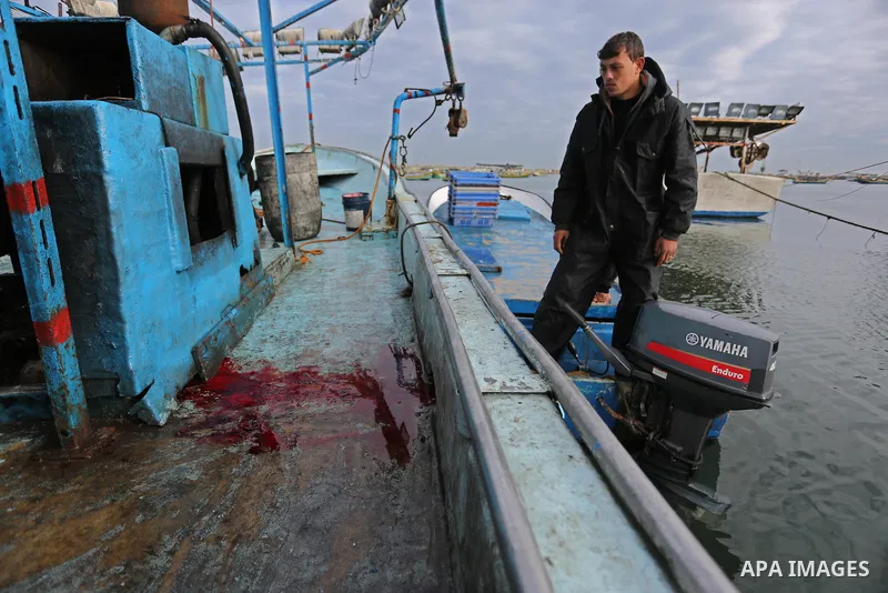 A Palestinian man inspects a boat at the port in Gaza City on February 26, 2018 in which a fisherman was killed when Israeli forces opened fire on it the previous day. A spokeswoman for the Israeli army said the boat "de...