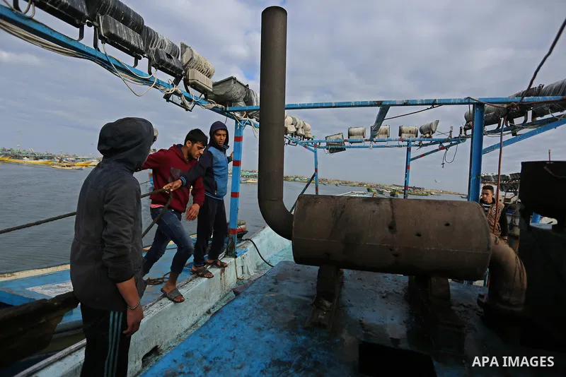 Palestinians inspect a boat at the port in Gaza City on February 26, 2018 in which a fisherman was killed when Israeli forces opened fire on it the previous day. A spokeswoman for the Israeli army said the boat "deviated...