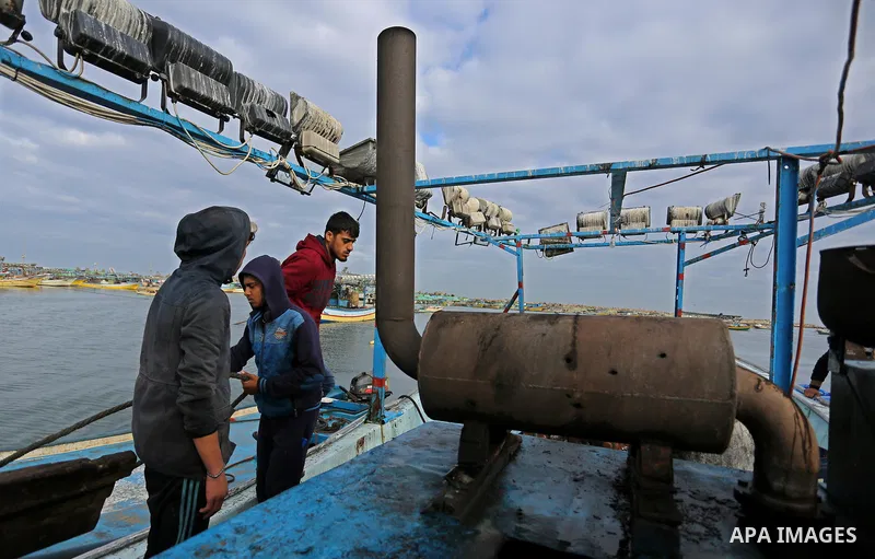 Palestinians inspect a boat at the port in Gaza City on February 26, 2018 in which a fisherman was killed when Israeli forces opened fire on it the previous day. A spokeswoman for the Israeli army said the boat "deviated...