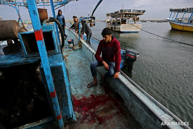 A Palestinian man inspects a boat at the port in Gaza City on February 26, 2018 in which a fisherman was killed when Israeli forces opened fire on it the previous day. A spokeswoman for the Israeli army said the boat "de...