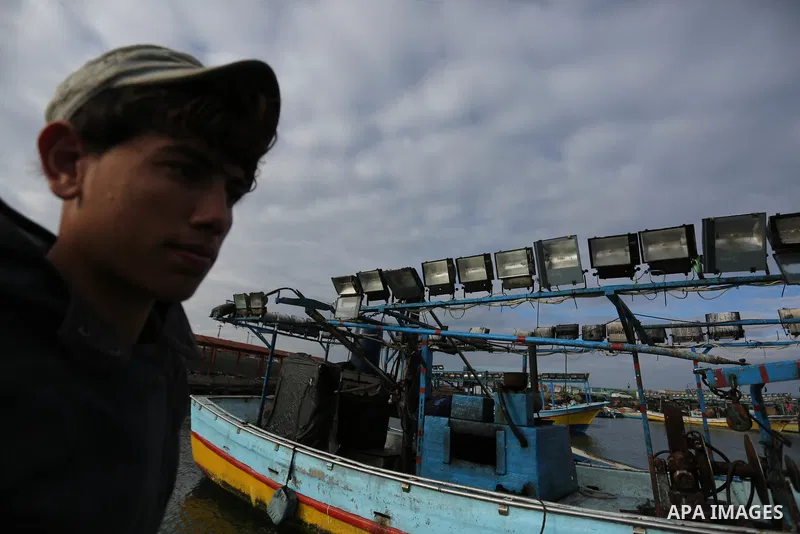 A Palestinian man stands next to a boat at the port in Gaza City on February 26, 2018 in which a fisherman was killed when Israeli forces opened fire on it the previous day. A spokeswoman for the Israeli army said the bo...