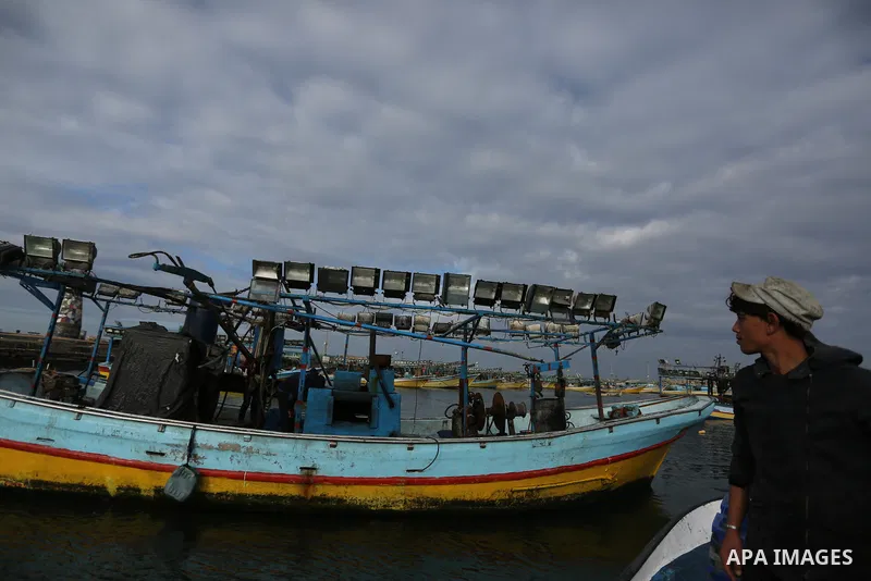 Palestinians inspect a boat at the port in Gaza City on February 26, 2018 in which a fisherman was killed when Israeli forces opened fire on it the previous day. A spokeswoman for the Israeli army said the boat "deviated...