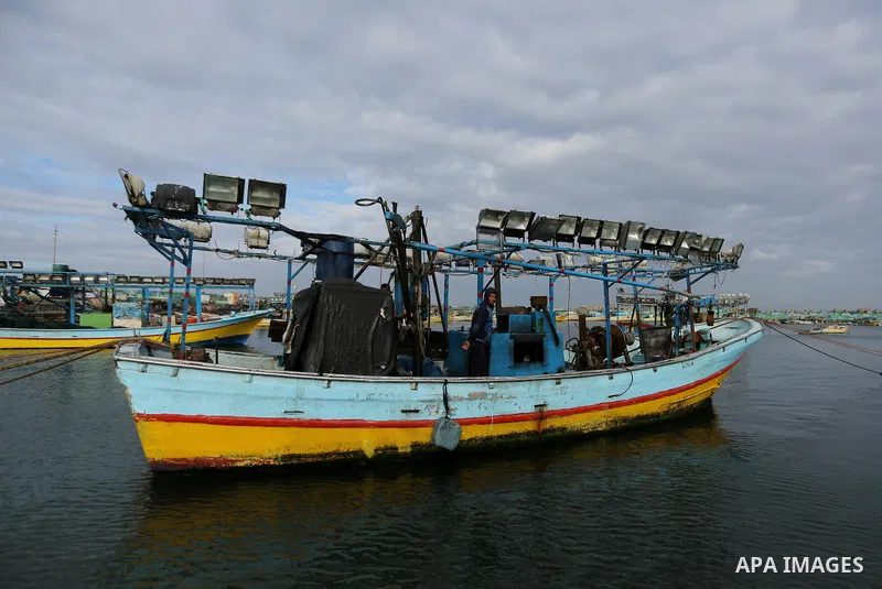 Palestinians inspect a boat at the port in Gaza City on February 26, 2018 in which a fisherman was killed when Israeli forces opened fire on it the previous day. A spokeswoman for the Israeli army said the boat "deviated...