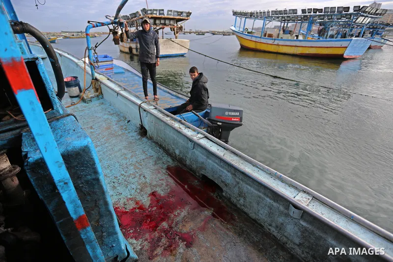 A Palestinian man inspects a boat at the port in Gaza City on February 26, 2018 in which a fisherman was killed when Israeli forces opened fire on it the previous day. A spokeswoman for the Israeli army said the boat "de...