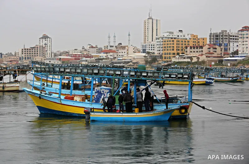 Palestinian fishermen work on their fishing boats at the port in Gaza City on February 26, 2018. A spokeswoman for the Israeli army said the boat "deviated from the designated fishing zone in the northern Gaza Strip. "Na...