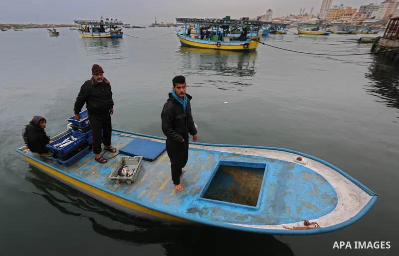Palestinian fishermen collect fish from nets at the port in Gaza City on February 26, 2018. A spokeswoman for the Israeli army said the boat "deviated from the designated fishing zone in the northern Gaza Strip. "Naval f...
