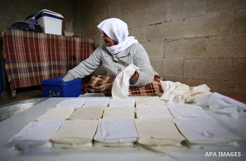 An elderly Palestinian woman Hayat Zeid , 80, makes templates of white cheese inside her home, in Kfairet village near the West Bank city of Jenin, on Febraruy 24, 2018. Hayat has been making cheese from sheep milk since...
