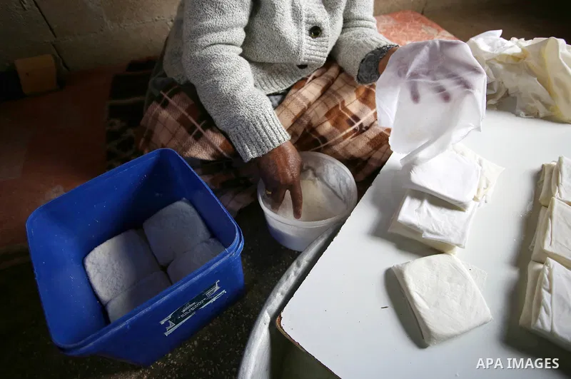 An elderly Palestinian woman Hayat Zeid , 80, makes templates of white cheese inside her home, in Kfairet village near the West Bank city of Jenin, on Febraruy 24, 2018. Hayat has been making cheese from sheep milk since...