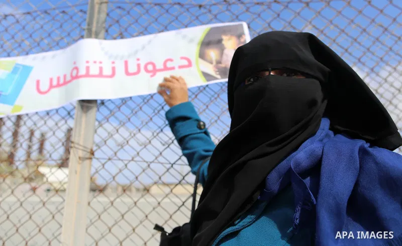 Palestinian women hold banners during a protest calling for an end to the power crisis, outside the power plant in the central Gaza Strip on February 27, 2018. Photo by Yasser Qudih