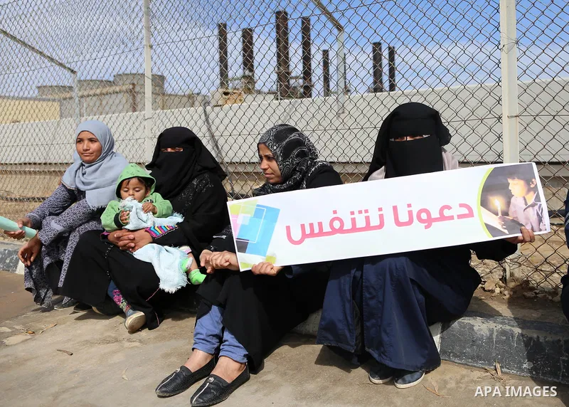 Palestinian women hold banners during a protest calling for an end to the power crisis, outside the power plant in the central Gaza Strip on February 27, 2018. Photo by Yasser Qudih