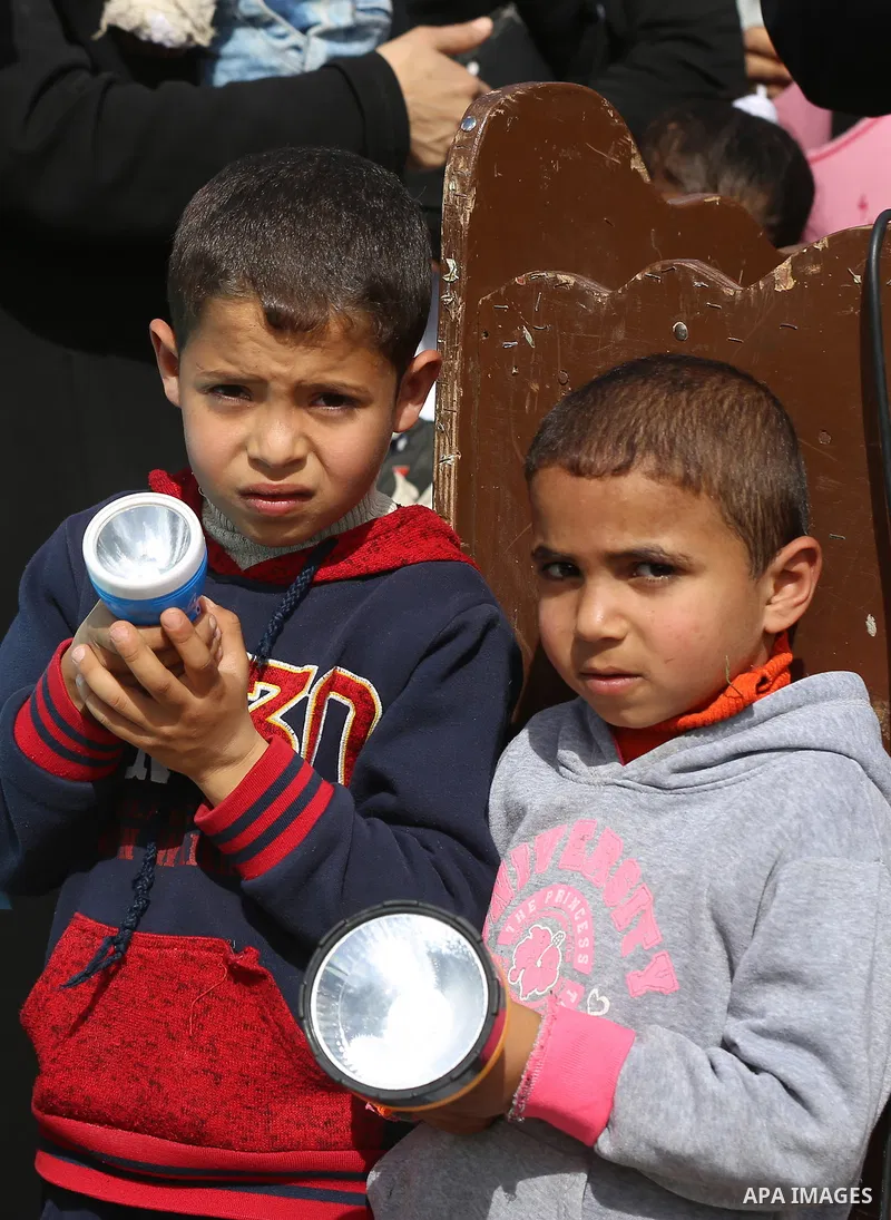 Palestinian children take part in a protest calling for an end to the power crisis, outside the power plant in the central Gaza Strip on February 27, 2018. Photo by Yasser Qudih