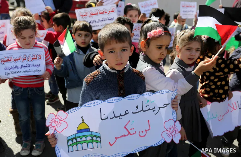 Palestinian children hold banners during a protest against U.S. President Donald Trump's decision to recognise Jerusalem as the capital of Israel, in front of the high commissioner for human rights headquarters, in Gaza...